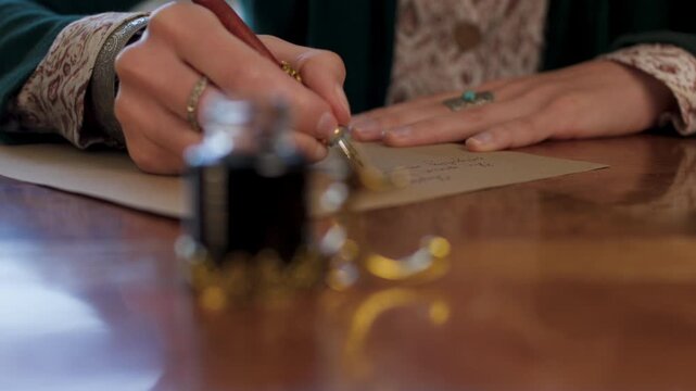 The girl is holding a pen with ink and writing a letter. The girl writes the letter in handwritten font. signing the document. 
