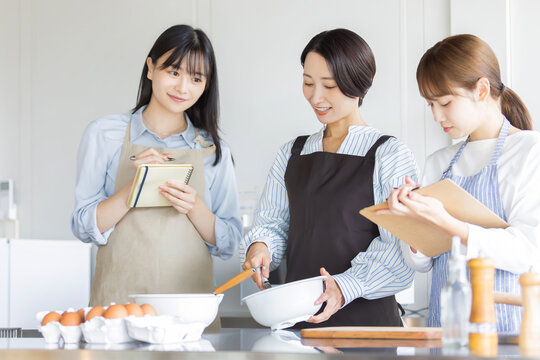料理教室で調理方法を学ぶ日本人女性たち