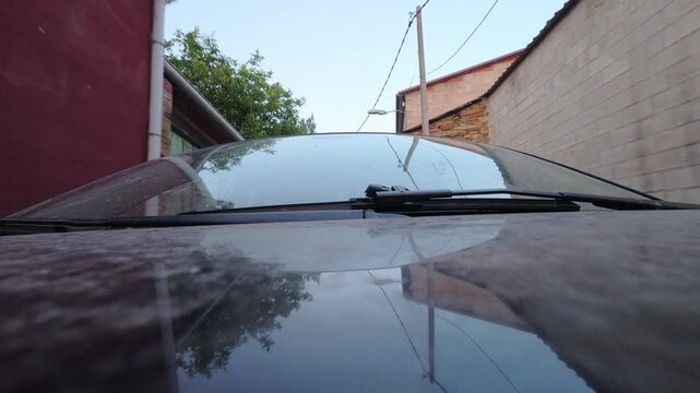 Low Angle Car Reflections Moving Through Narrow Urban Street