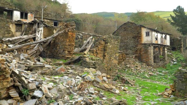 Ruined stone houses and abandoned buildings in Santoalla do Monte, a remote village in Galicia, Spain, showing the visible effects of rural depopulation and long-term decay