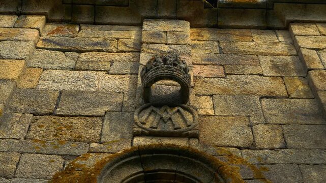 Close view of weathered carved stone and architectural details on the historic Church of Santa Mar&iacute;a de Mones in Pet&iacute;n, Galicia, Spain
