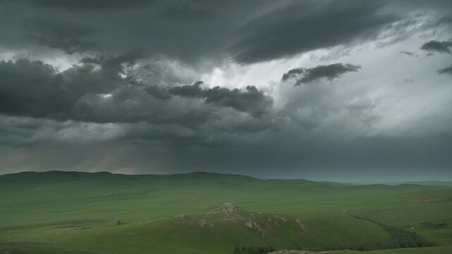 Empty Mongolian grasslands before rain with dark storm clouds sweeping across the steppe.