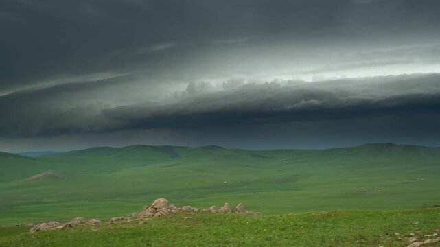 Empty Mongolian grasslands before rain with dark storm clouds sweeping across the steppe.