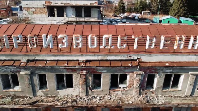 An old Soviet-era building with a walkway leading to an abandoned factory.