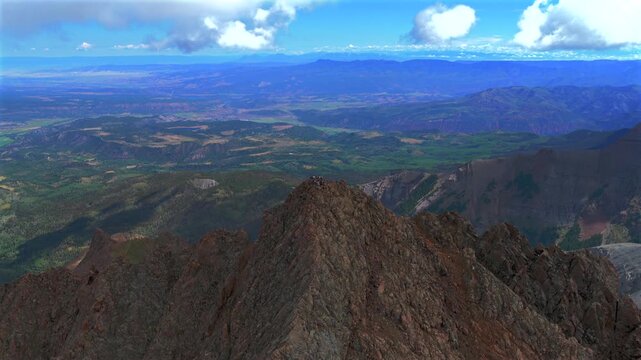 Mountt Sneffels 14er South Slope Hikers top of summit Mt Sneffels Wilderness landscape Yankee Boy Basin trail Ridgway Colorado aerial drone view San Juan Range Rockies morning sunny clouds forward