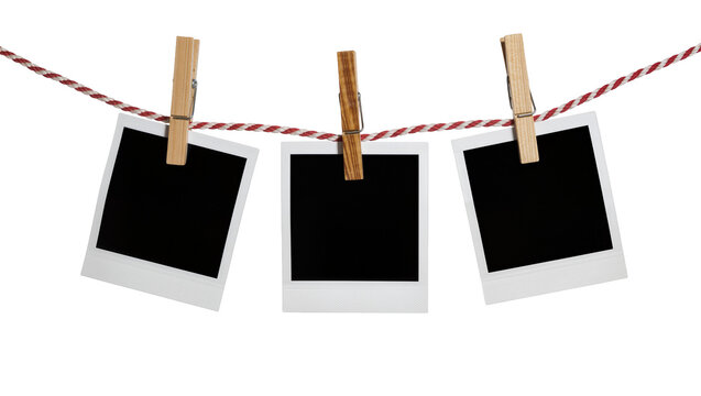 Three blank instant photo prints with wooden clothespins on a rope, isolated on transparent background