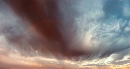 Obraz premium Panoramic Rainbow and Dramatic Storm Clouds at Sunrise After Rain