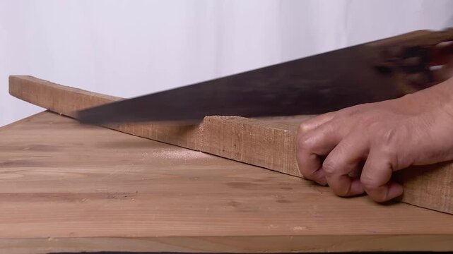 Sawing wood with hand saw