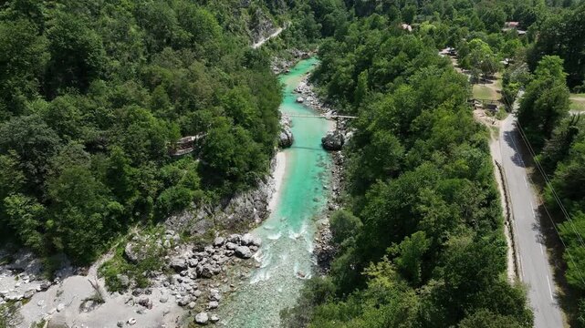 Aerial top down perspective captures turquoise Soca river crystal clear water. rocky canyon banks surrounded by dense wild green forest near Kobarid.