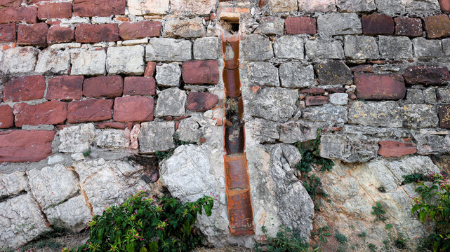 Pared con distintos tipos de piedras y una conducci&oacute;n de teja