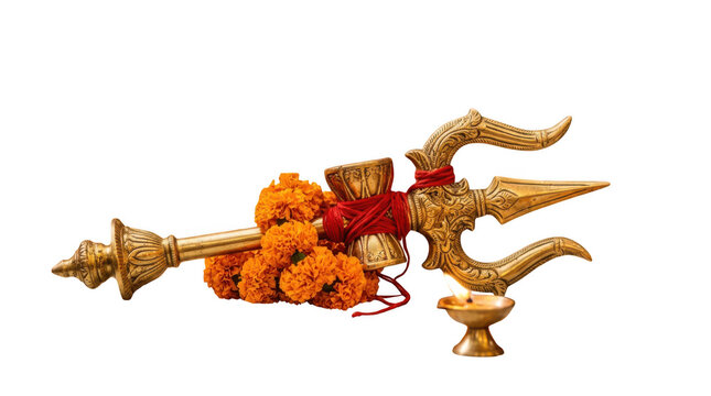 Golden trishul symbol of lord shiva decorated with bright orange marigold flowers and a small oil lamp for hindu religious worship and traditional spiritual festivals
