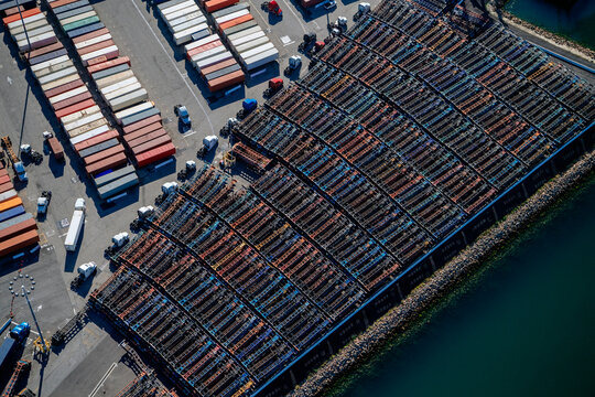 Aerial view of container ships and trucks at dockyard in a beach
