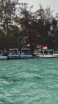 Jakarta, Indonesia - April 24, 2026: Wooden motorboat with Indonesian flag anchored in clear sea