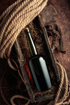 An antique bottle of hard liquor in a vintage wooden box.