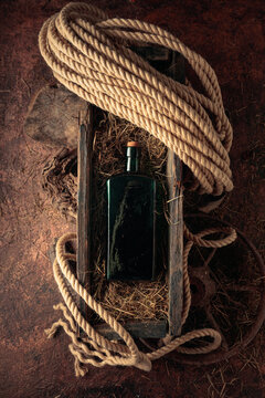 An antique bottle of hard liquor in a vintage wooden box.