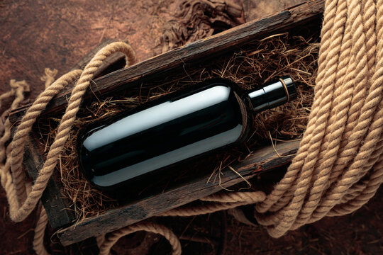 Dark glass bottle of hard liquor in a vintage wooden box.