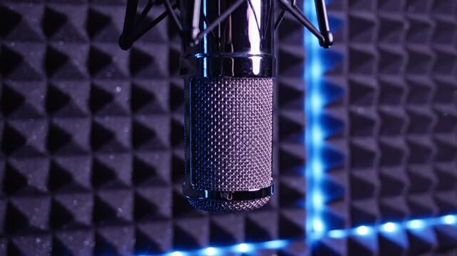 Close-up of a Shiny Silver Microphone in a Recording Studio with Acoustic Foam and Blue Lighting