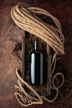Dark glass bottle of hard liquor in a vintage wooden box.