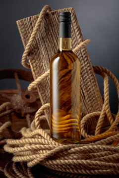 Bottle of  white wine with old weathered board and hemp rope.