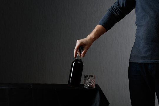 Man picks up a bottle of rum.
