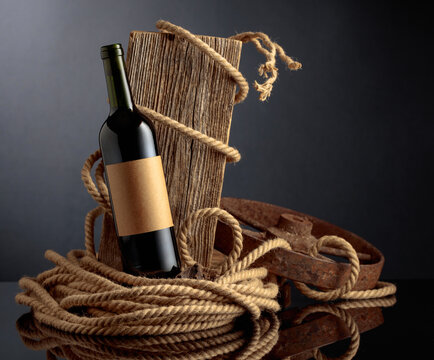 Bottle of port wine with old weathered board and hemp rope.