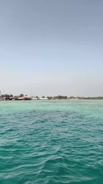 Vertical view of clear turquoise sea water surface with island