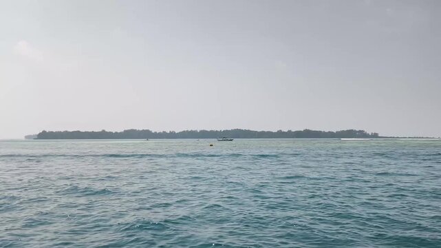 Wide ocean horizon line with distant tropical island