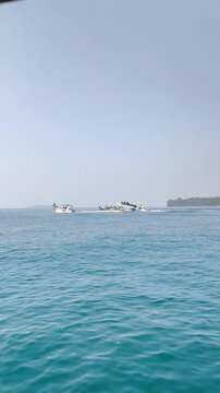 Blue ocean water with calm waves and horizon island view
