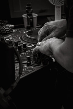Close-Up of DJ Hands Adjusting Fader Control Knob on Audio Mixer