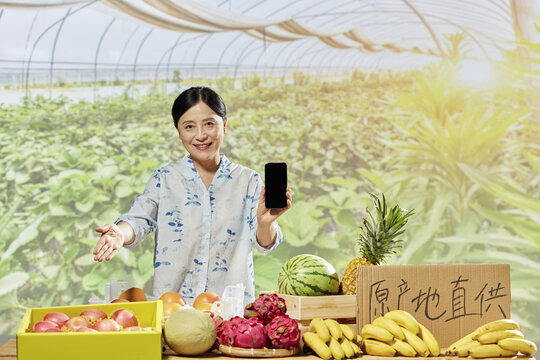 Smiling Asian Woman Farmer Selling Fresh Fruit Online in a Greenhouse