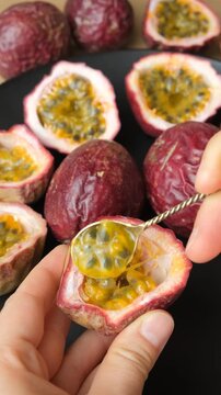Macro video of person gathering ripe maracuya pulp with small spoon