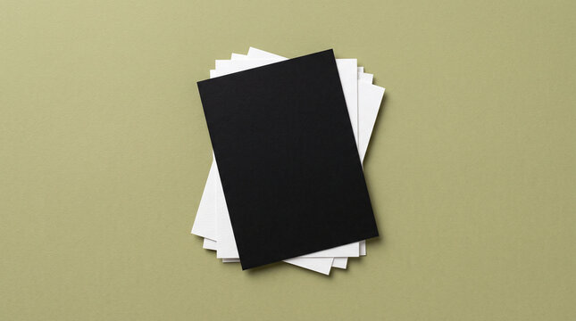Black and white paper stack mockup photo. Blank rectangular cards layered on olive green background. Minimalist stationery presentation for branding design and commercial stationery.