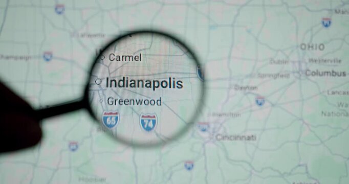 Magnifying glass passing over a digital map showing Indianapolis, the capital city of the state of Indiana, focusing on its geographical location and nearby highways like I-65 and I-74