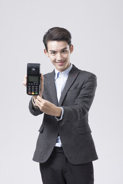 Smiling Young Businessman Holding Card Payment Terminal
