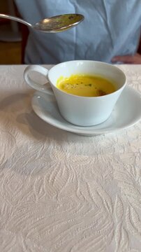 レストランでコンスープを飲む男性