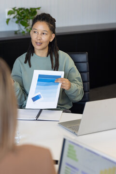 African American team reviewing blue swatches at meeting table woman green top holding sample card