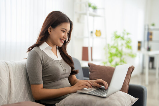 Woman self employed working online using computer at home.