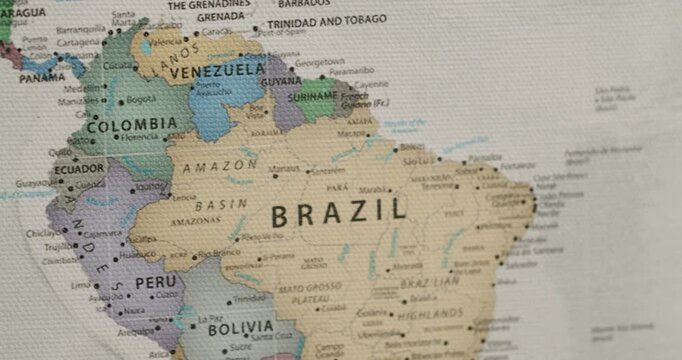 Detailed view of a vintage-style canvas world map slowly panning over the continent of South America, showing countries like Brazil, Peru, Colombia, Venezuela, and Bolivia with their major cities