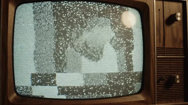 Vintage Television Static Screen - A close-up of a vintage wooden television displaying static on its screen.