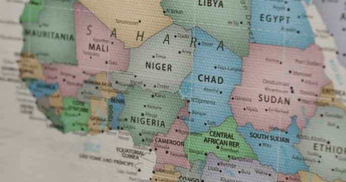 Detailed view of a colorful political map focusing on Africa, showing nations like Nigeria, Niger, Chad, and Sudan. The canvas texture of the map is visible, adding a vintage and educational feel