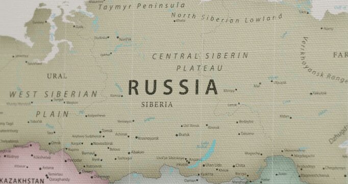 Close-up of a vintage-style canvas map focusing on the territory of Russia, including Siberia, the Ural mountains, Kazakhstan, and major cities across the vast expanse of the country