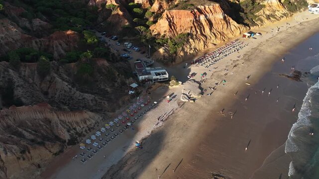 Falesia Beach, Algarve, Portugal. Golden mile beach with orange rocks, golden sand and turquoise sea. Aerial drone top view perspective. Famous travel destination in south of Portugal 