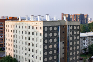 Multi-story residential building featuring iconic Soviet architectural design with patterned concrete panels and multiple windows. Surrounding high-rise apartment complexes and greenery are visible un © Yarr