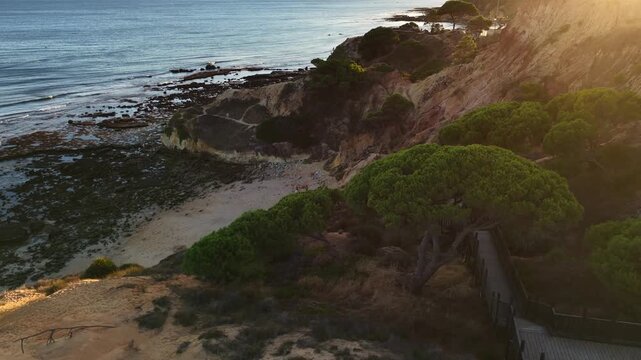 Falesia Beach, Algarve, Portugal. Golden mile beach with orange rocks, golden sand and turquoise sea. Aerial drone top view perspective. Famous travel destination in south of Portugal 