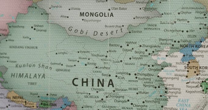 Detailed political map showing China, Mongolia, the Gobi Desert, and Japan with countries, cities, and borders marked on a textured canvas surface, highlighting the geography of East Asia