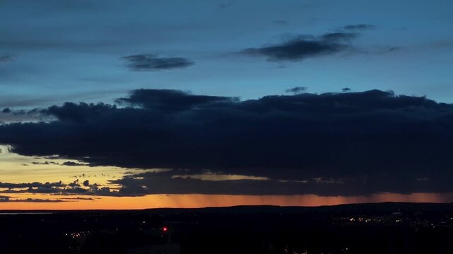 gradient orange blue sunset dusk with storm clouds silhouette pouring rain dramatic sky footage