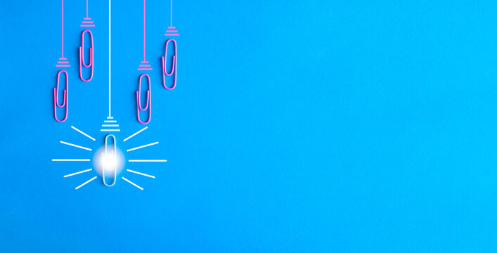  innovation concept with paperclip,thinking,creativity,light bulb on blue background,business and society concept. Large free copy space.
