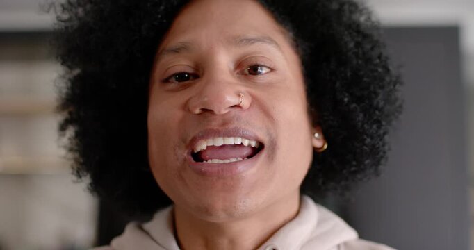 African American man starting, talking to camera, sharing story in kitchen, hoodie, nose-ring