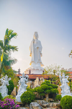 large white lady buddha statue with guardian figures