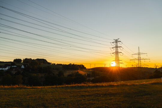 Sunset Over Rural Landscape With High-Voltage Power Lines